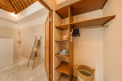 a bathroom with a closet with wooden shelves at Tropical 2BR Pool Villa near Seminyak & Canggu in Kerobokan