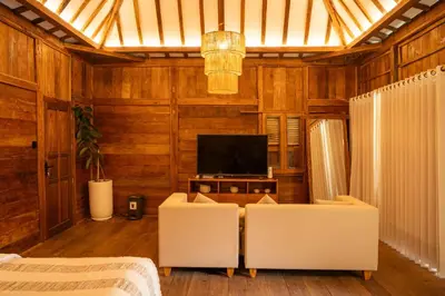 a living room with two white chairs and a television at Tuluscoliving Villa Kuta 3, 3 Bedroom & 3 Bathroom in Ngurah Rai International Airport