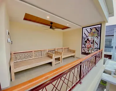 a balcony with benches and a painting on the wall at quiet and comfortable villa in sanur kauh in Sanur
