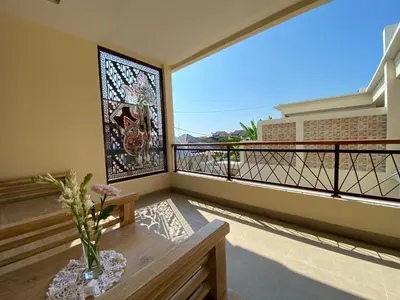 a balcony with a stained glass window and a vase with flowers at quiet and comfortable villa in sanur kauh in Sanur