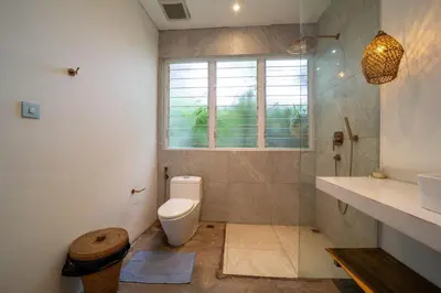 a bathroom with a toilet and a sink and a window at Luxury 2BR Dharma Villa 5 Private Pool in Canggu in Canggu
