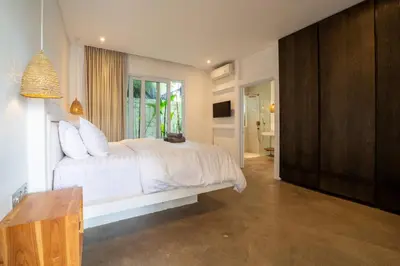 a bedroom with a white bed and a window at Luxury 2BR Dharma Villa 5 Private Pool in Canggu in Canggu