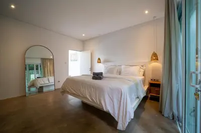 a bedroom with a large white bed and a mirror at Luxury 2BR Dharma Villa 5 Private Pool in Canggu in Canggu