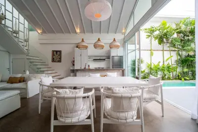 a dining room with a white table and chairs at Luxury 2BR Dharma Villa 5 Private Pool in Canggu in Canggu