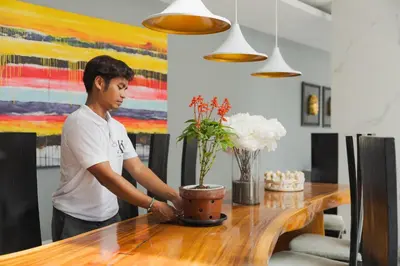 a man standing in front of a table with a vase at Xxtra Villa in Seminyak