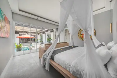 a bedroom with a bed with a mosquito net at Xxtra Villa in Seminyak