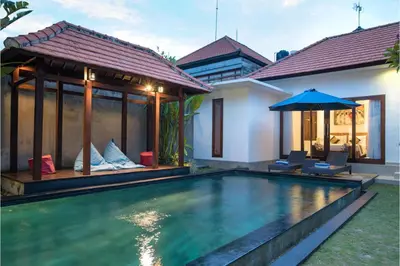 a villa with a swimming pool and a house at Kubu Manggala Villas Seminyak in Seminyak