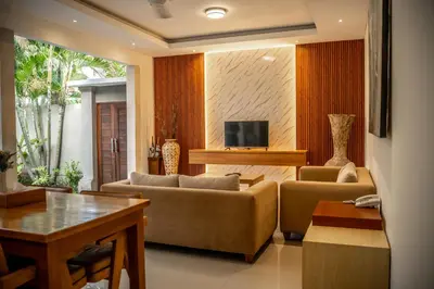 a living room with two couches and a tv at Kubu Manggala Villas Seminyak in Seminyak