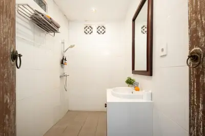 a white bathroom with a sink and a mirror at Red Lotus Seminyak Villa in Seminyak