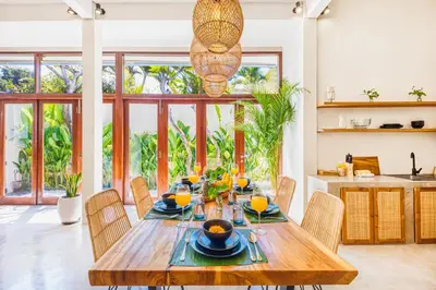 a dining room with a wooden table and chairs at 3BR Villa | Seminyak Central | 450m From Beach in Seminyak