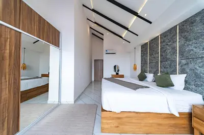 a bedroom with a large white bed with green pillows at Seminyak Loft 360 by Villas R Us in Seminyak