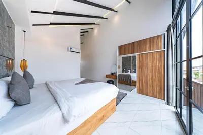 a bedroom with a bed and a large window at Seminyak Loft 360 by Villas R Us in Seminyak