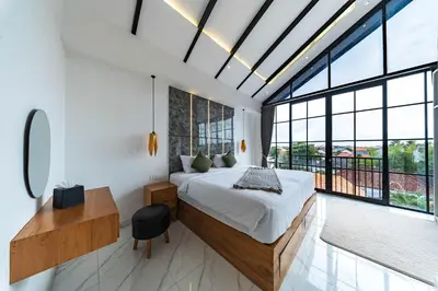 a bedroom with a bed and a large window at Seminyak Loft 360 by Villas R Us in Seminyak