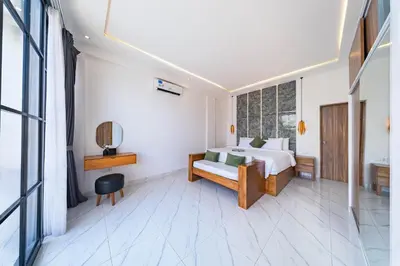 a white bedroom with a bed and a window at Seminyak Loft 360 by Villas R Us in Seminyak