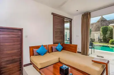 a living room with a couch and a pool at Ekavira Peaceful 2 BR Private Pool Villa in Seminyak