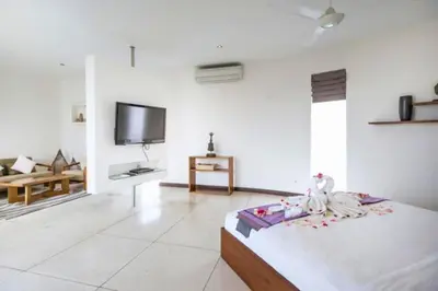 a white living room with a bed and a tv at Ekavira Peaceful 2 BR Private Pool Villa in Seminyak