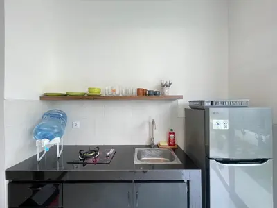 a small kitchen with a sink and a refrigerator at Gede Awan Guesthouse in Kerobokan