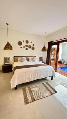 a bedroom with a large bed in a room at Villa Harmaka in Kerobokan