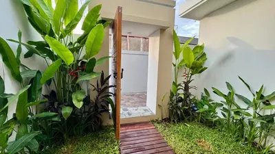 a door leading into a yard with plants at Villa Harmaka in Kerobokan