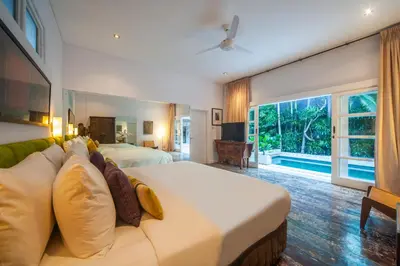 a hotel room with two beds and a couch at Tides Seminyak in Seminyak