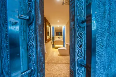 a bathroom with a toilet and a blue door at Tides Seminyak in Seminyak