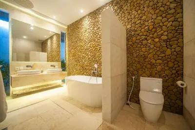 a bathroom with a tub and a toilet and a sink at Tides Seminyak in Seminyak