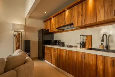 a kitchen with wooden cabinets and a counter top at Villa Lediana - 3BR Private pool in Canggu