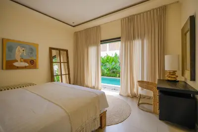 a bedroom with a bed and a desk and a window at Villa Lediana - 3BR Private pool in Canggu