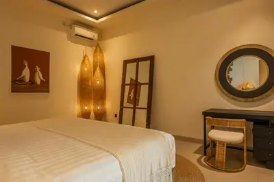 a bedroom with a bed and a mirror at Villa Lediana - 3BR Private pool in Canggu
