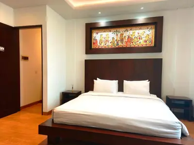 a bedroom with a bed with a painting above it at Tahoma Villas Nakula by ABM in Legian