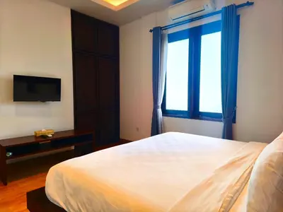 a bedroom with a large bed and a window at Tahoma Villas Nakula by ABM in Legian