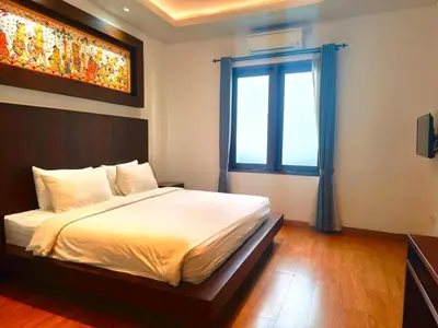 a bedroom with a large bed and a window at Tahoma Villas Nakula by ABM in Legian