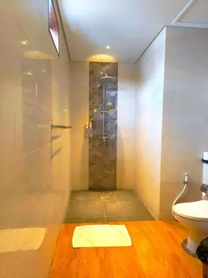 a bathroom with a shower with a sink and a toilet at Tahoma Villas Nakula by ABM in Legian