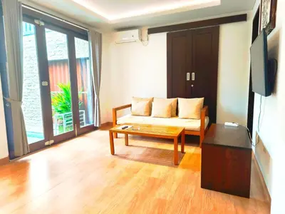 a living room with a couch and a flat screen tv at Tahoma Villas Nakula by ABM in Legian