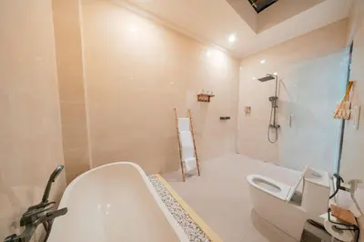 a bathroom with a tub and a shower and a sink at Villa Tyaga in Kerobokan
