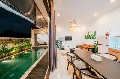 a kitchen and living room with a swimming pool in a house at Villa Tyaga in Kerobokan
