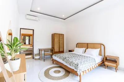 a bedroom with a bed and a table and a mirror at Canggu 3BR Private Pool Villa 3 min to Beach Finns in Canggu