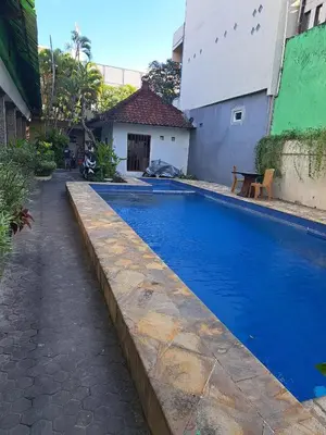 a swimming pool with blue water in a yard at Jimmy's Hideaway at Mulia Cottages in Seminyak