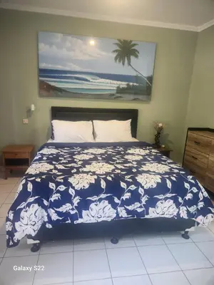a bedroom with a bed with a blue and white blanket at Jimmy's Hideaway at Mulia Cottages in Seminyak