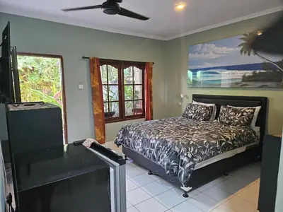 a bedroom with a bed and a window at Jimmy's Hideaway at Mulia Cottages in Seminyak