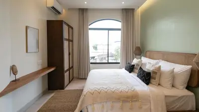 a bedroom with a large bed with a window at Casa Amani 3BR Mediterranean w Pool Near Seminyak in Kerobokan
