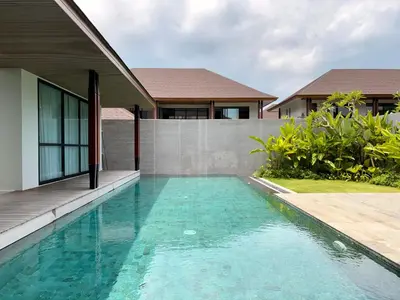 a swimming pool in front of a house at Villa Daun Emas in Jimbaran