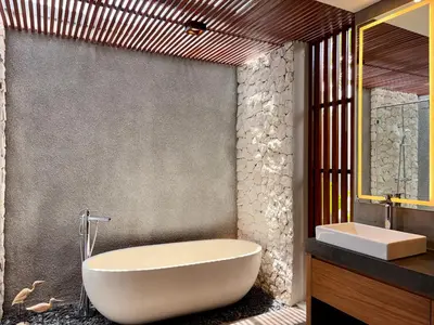 a bathroom with a white tub and a sink at Villa Daun Emas in Jimbaran