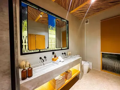 a bathroom with a sink and a large mirror at Desa Hut - Tropical Haven with Ricefield View near Seminyak in Kerobokan