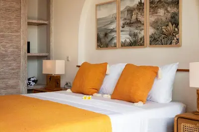 a bedroom with a white bed with orange pillows at NEW Villa Chim Chim Modern 2BR Tropical with Pool in Seminyak
