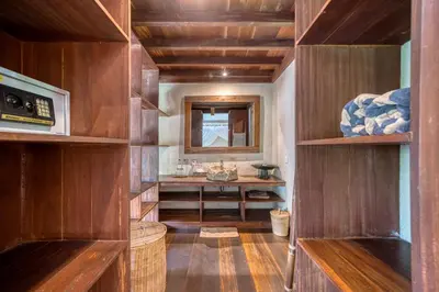 a bathroom with wooden shelves and a sink at Nomadic Resort Bali in Canggu