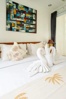 a bed with two white swans sitting on it at Mertasari Beach Villa Sanur - 3 BR in Sanur