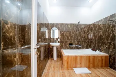 a bathroom with a tub and a sink at Mertasari Beach Villa Sanur - 3 BR in Sanur