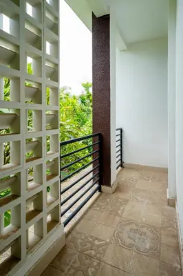 a room with a balcony with a wall of shelves at Mertasari Beach Villa Sanur - 3 BR in Sanur