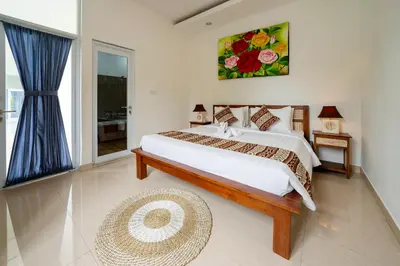 a bedroom with a large bed and a window at Mertasari Beach Villa Sanur - 3 BR in Sanur
